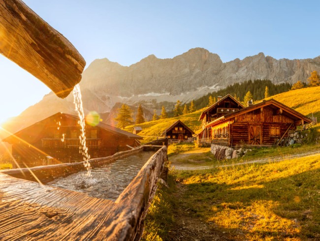Trinkwasserbrunnen und Sonnenuntergang auf der Neustattalm in Ramsau am Dachstein